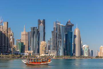 Doha, Qatar - JAN 8th 2018: The West Bay City skyline with a local boat in a beautiful blue sky day in winter - Jan 8th, 2018 in Doha, Qatar. The West Bay one of the most prominent districts of Doha