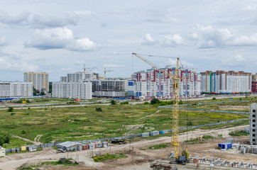 The crane works at the construction site. Building with a crane