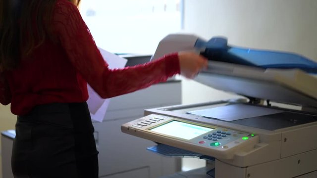 Attractive business lady working with scaner. and photocopies. Secretary female in office. Business Documents concept. Shot in 4K (UHD).