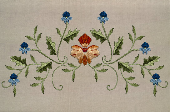 Embroidery for pattern with red-yellow flower and blue flowers on twisted stems with leaves on cotton fabric



