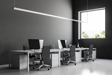 Row of computer desks in gray office side view