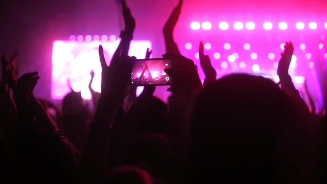 A man takes a picture with his smartphone in a concert