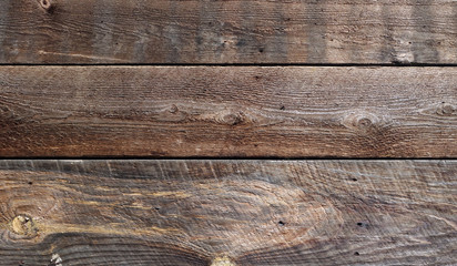 Unfinished barn board siding showing weathering, grain, knotholes and years of abuse