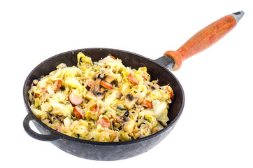 Frying pan with fried cabbage, sausages and mushrooms on white background