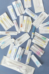 medical needles of various types and colors on a blue background