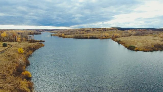 Aerial video of a lake at countryside. Drone moving forward. Aerial stock footage shot at autumn season time.