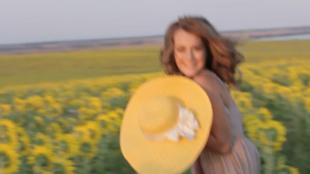 beautiful girl in hat and dress rural nature in the sunflowers in the sunset walking