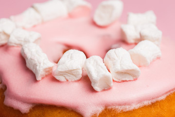 Fototapeta na wymiar Pink donut with marshmallows on a Pink background