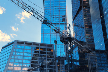 Crane construction bricks concrete building in city downtown skyscrapers