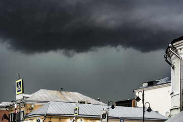 heavy rain and massive clouds flying over the europe city rooftops