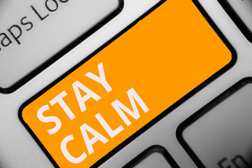 Writing note showing Stay Calm. Business photo showcasing Maintain in a state of motion smoothly even under pressure Keyboard orange key Intention computer computing reflection document.