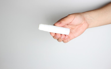 Glue stick in hand on a light background