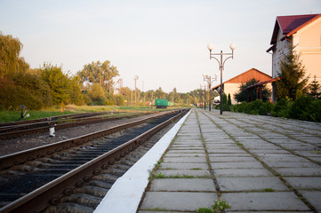 Fototapeta premium railway tracks lead to the station on a summer