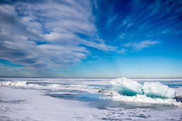 Fototapeta premium Blue turquoise ice heaves on a frozen lake in Canada.