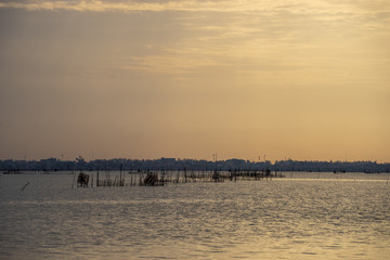 Morning scene of Songkhla lake, Southern Thailand with fish cages in the middle.