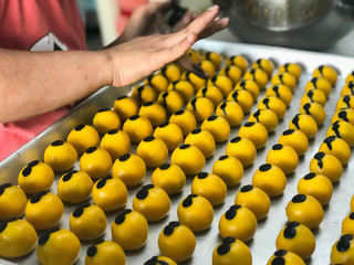 The woman is making cookies Minions shaped stuffed with pineapple.