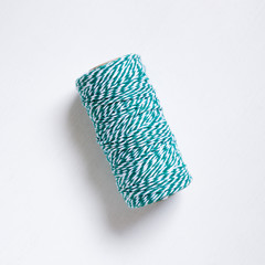 Green thread reel on white background