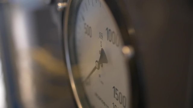 A focus pull of a piece of technology, probably a barometer, in a technical lab