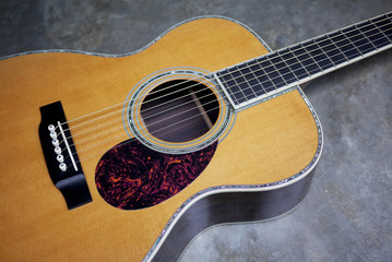 Detail of classic guitar on concrete background with shallow depth of field