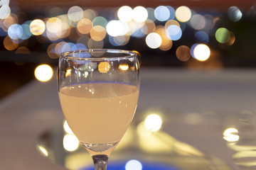 Grapefruit juice on a table with the view of Villa Carlos Paz, Cordoba, Argentina in the background, with blurred city lights