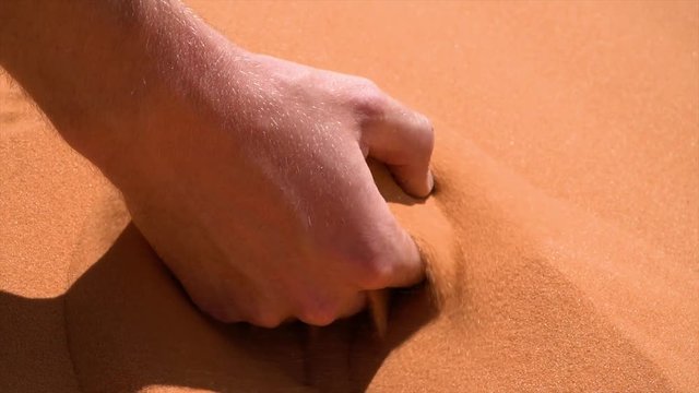 Hand Picking up Sand - Desert