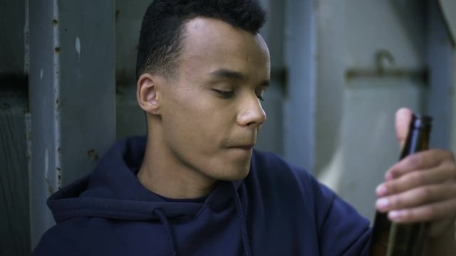 Guy drinking beer trying to calm down inner pain and depression, teenage years