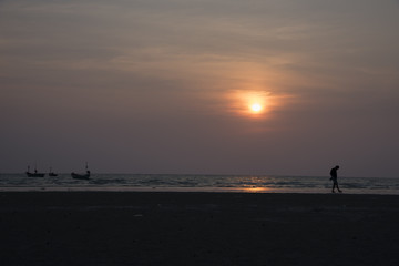 Fototapeta premium Silhouette people on the beach at golden sunset time