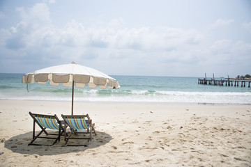 Fototapeta na wymiar Two beach chairs on the sand beach