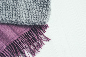 Gray woolen knitted hat and pink scarf on a white background