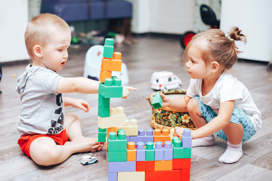 little boy and girl playing toys at home