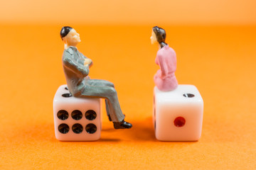 サイコロに座って会話する男女