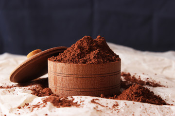 Cocoa in wooden utensils on a dark background.