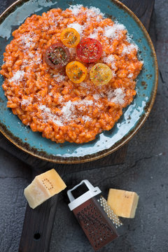 Turquoise plate with tomato risotto, view from above, vertical shot, close-up