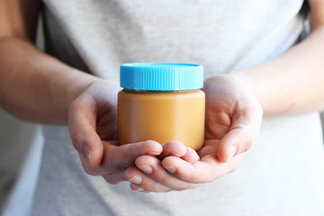 Nut paste in male hands on a light background.