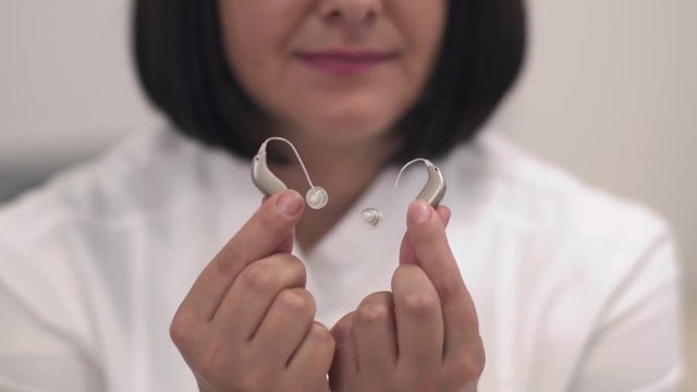 Employee of a medical clinic shows a hearing aid