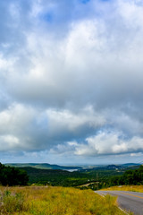 Open Road in the hill country underneath clouds and open sky.