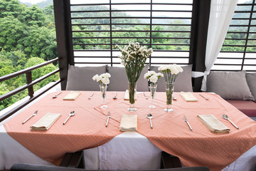 table set for wedding or event party.With orange tablecloth.Elegant and luxury decoration in soft white with flowers.