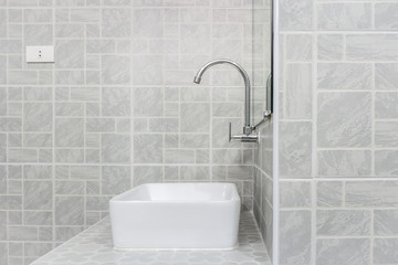 Side view of new modern grey restroom. It consists of mirror, ceramic wash basin, countertop and...