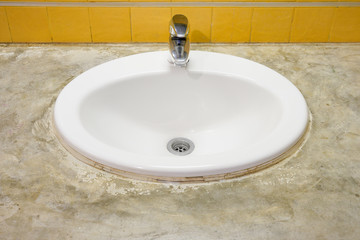 Fototapeta premium Oval bathroom sink with faucet. It is mounted on concrete countertop.