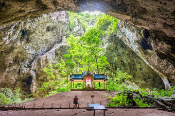 Khuha Kharuehat Throne in the center of cave's chamber with tourist woman. The tourist attraction at Phraya Nakhon cave in Khao Sam Roi Yot National Park, Prachuap Khiri Khan, Thailand.