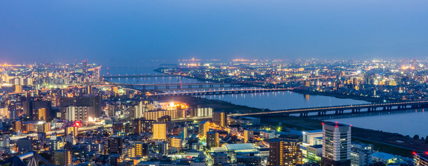 Plakat Osaka panorama cityscapes with Yodo river at night. Scenery from Kuchu Teien Observatory on Umeda Sky Building.