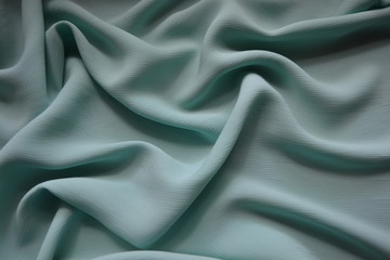 Fototapeta premium Gray-blue soft cloth draped in waves