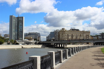 Moscow, Russia - Day view of the Department of national policy, Moscow river and Novoarbatsky bridge from Shevchenko embankment against the blue sky and white clouds