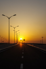 A Row of Lamps in the Road at Sunset