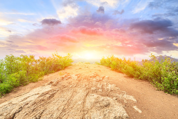 Mountain peak rock road platform and green trees at sunrise