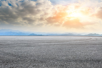Empty asphalt square car tire brakes and mountain scenery at sunrise