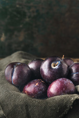Red plums on rustic background