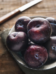 Red plums on rustic background