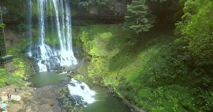 waterfall streams break on huge boulders on bottom
