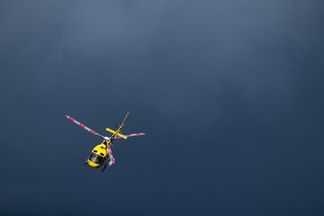 Elicottero giallo di soccorso in volo su un cielo di colore blue scuro. molto drammatico
